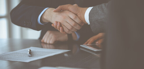 Naklejka premium Handshake as successful negotiation ending, close-up. Unknown business people shaking hands after contract signing in modern office