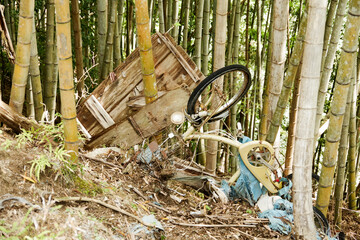 0ozore, Shizuoka, Japan, 04-22-2021, trash and abandoned bikes left in the bamboo forest in an abandoned town in Oozore.