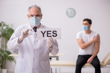 Young male patient visiting old male doctor in vaccination conce