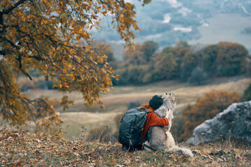 woman hiker hugging with dog on nature in the mountains travel friendship