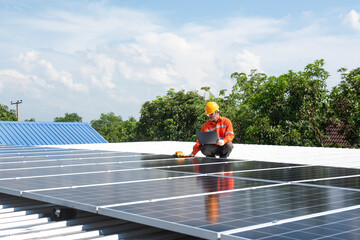Asian technician Solar panels with a drill to install solar panels on the roof.