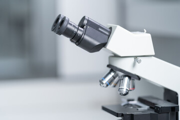 Fototapeta na wymiar Close-up and selective focus shoot of a microscope, medical test tubes with liquid, and other modern laboratory equipment in a laboratory room. Education stock photo