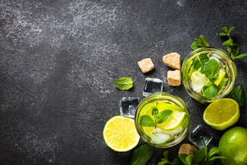 Mojito cocktail on black stone background top view.