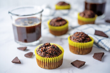 Chocolate muffins with chocolate sprinkles and glasses of coffee