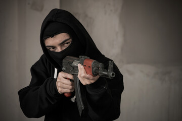 Terrorist hold a pistol gun aiming eye contact with blurred background.