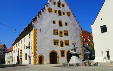 Alter Tändelmarkt in Nördlingen mit Blechskulptur vor mittelalterlicher Fassade unter blauem Himmel 