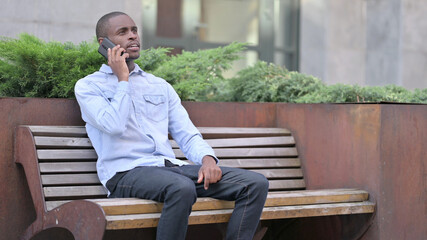 Fototapeta premium Attractive African Man Talking on Phone Outdoor 