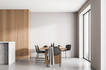 Light kitchen interior with table and chairs on concrete floor, mockup