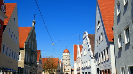 Stadtansicht von Nördlingen mit Löpsinger Tor und Stadtmauer mit Giebelhäusern unter blauem Himmel