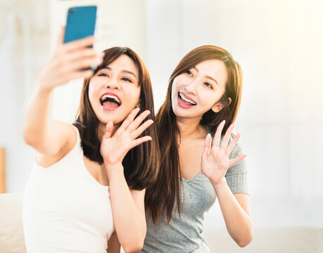 Happy girls taking a selfie picture with  smartphone at home