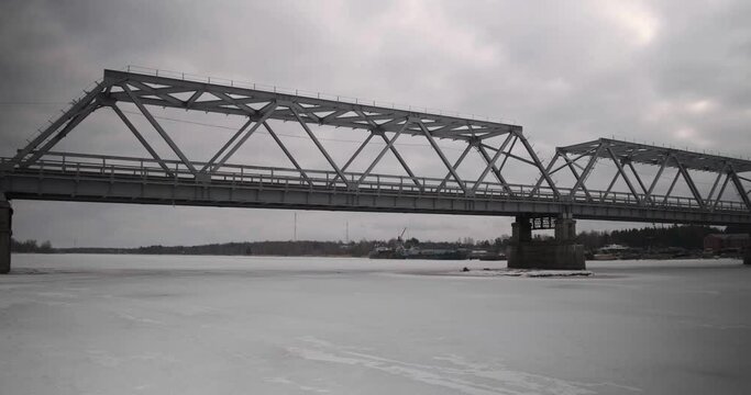 bridge over the river in the village of Ust-Luga on a cloudy winter day