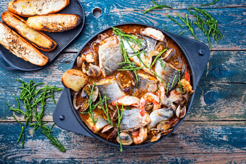 Modern style traditional Spanish seafood zarzuela de pescado with fish, king prawns and venus clams...