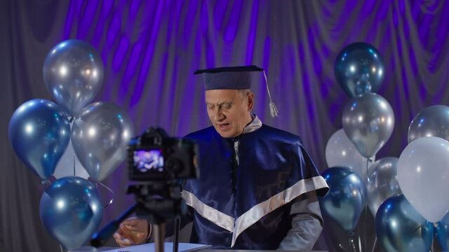 male dean of university congratulates students on graduation and presents diplomas online communicating with students online in conference hall