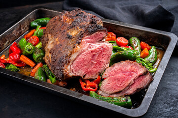 Traditional English barbecue lamb roast with vegetable and gravy sauce offered as close-up in a...