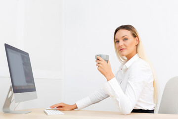 Beautiful businesswoman looking at camera with a cup of coffee in her hand.