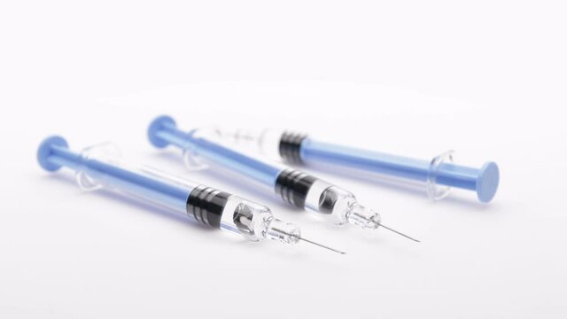 syringes with the vaccine or medical supplies on a white background (looping)