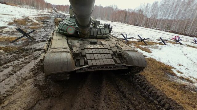 Military tank rides in the forest through the mud, tank biathlon