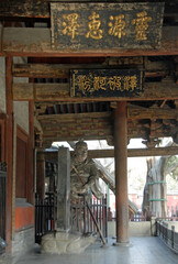 Jinci Temple near Taiyuan, Shanxi , China. A fearsome statue and Chinese characters at the front of Shengmu Hall or Holy Mother Hall, the earliest existing main hall of Jinci Temple.
