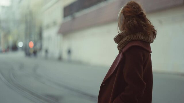 sad girl standing on a city avenue among people