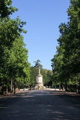 Interior of a Pamplona park with trees around and a statue in the background