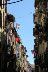 Pamplona street with balconies, shadows and some Basque flag