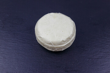 Soft Adyghe cheese on black slate background