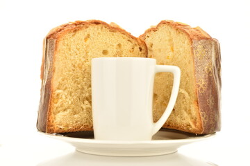 Two halves of a freshly baked Easter muffin on a white plate with a white cup, macro, isolated on white.