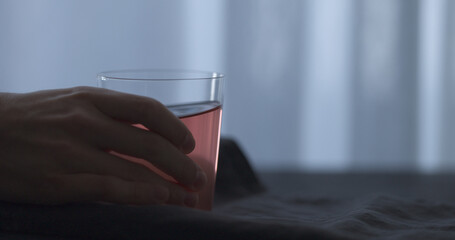 man hand take rose drink in tumbler glass from linen cloth