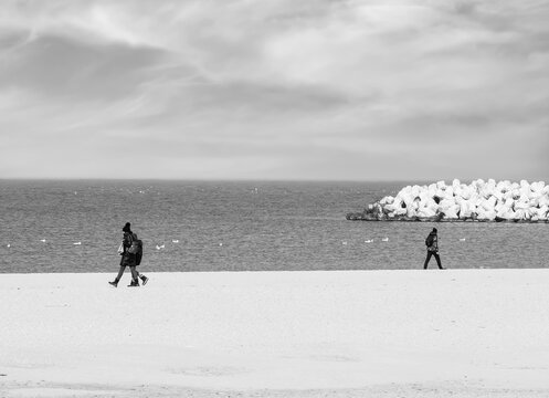 Black And White Picture With People Walking In Opposite Directio