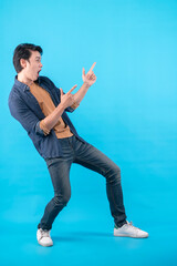 Cheerful Asian male man indicate thumb empty space hand gesture finger point wide smile open mouth...