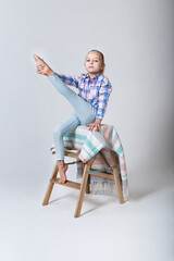 girl gymnast in regular clothes sits on a chair and stretches