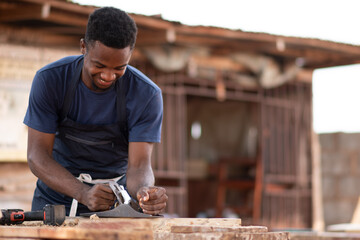 african carpenter smiling while working