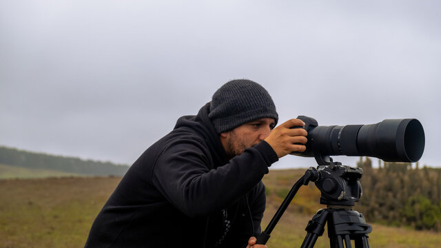 Surf and nature photographer taking photos on a cloudy day with his camera and telephoto,Chilean
