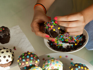 Hands decorating cupcake with confetti 