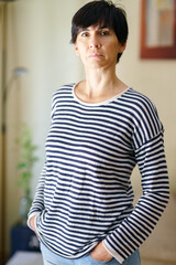 Middle-aged woman posing at home looking at the camera with serenity.