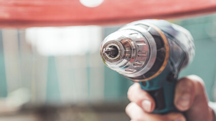Do it yourself: Home Handyman is holding a cordless screwdriver, outdoors