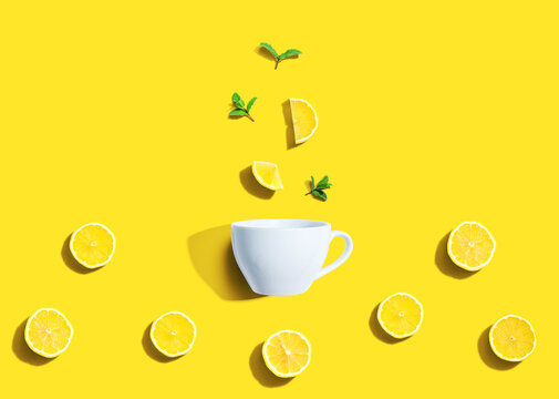 Fresh yellow lemons with tea cup overhead view