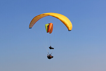 Paragliders flying  in a blue sky	