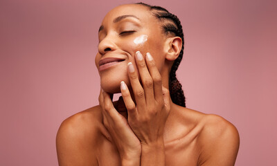 Woman using moisturizer on her face