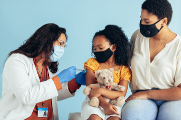 Doctor giving coronavirus vaccine to a girl
