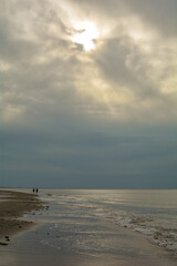 Sand beach with waves on the North Sea coast with people