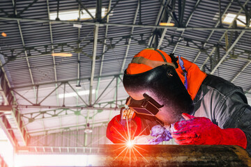 Welder is welding with spark light in workshop for construction welding