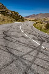 Black tire burnout tire tracks on rural road due to illigal car drifting