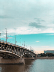 A bridge through the river under the clouds and blue sky
