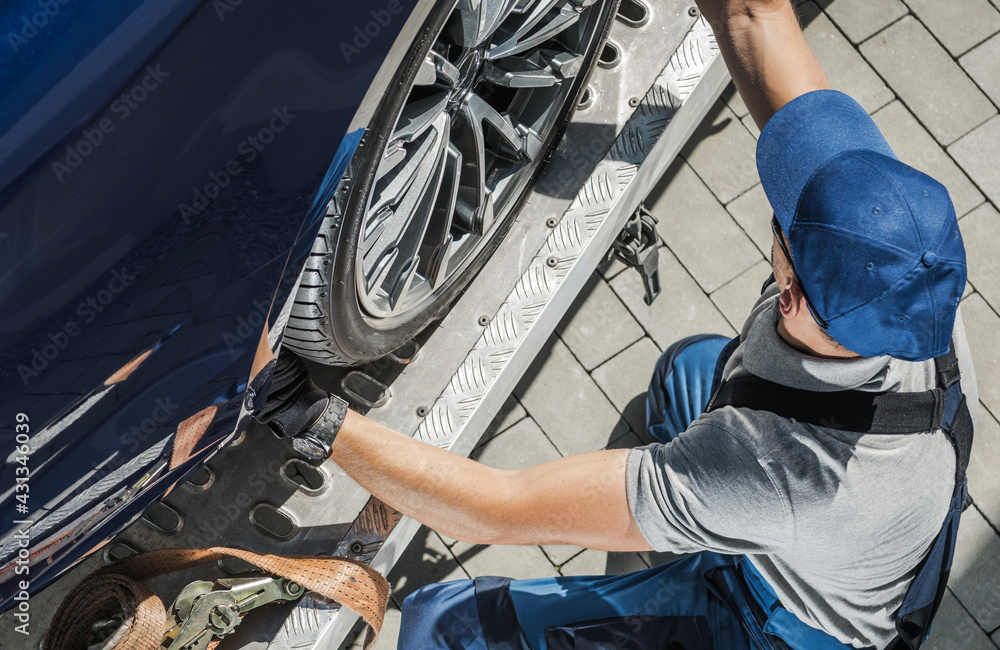 Wall mural Automobile Towing Worker Securing Car on His Tow Truck