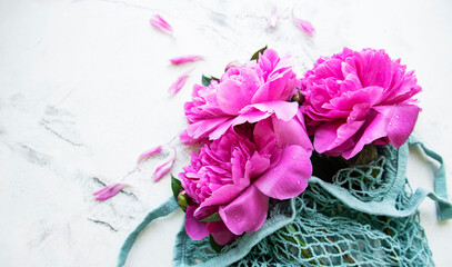 Fototapeta premium Pink peony flowers in string bag
