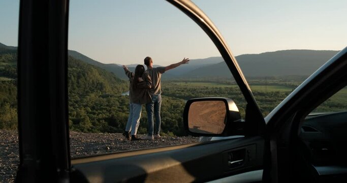 Young Traveler Couple on Road Trip, Man and Woman Enjoying Journey on Their Car Over Beautiful Landscape