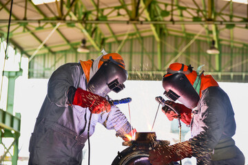 Welder team welding industrial factory welding process light spark equipment protective PPE for...