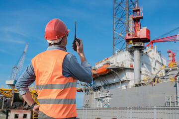 Workers hand holding walkie talkie control work during ship repair and maintenance in shipyard