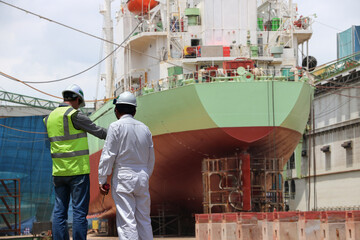 Shipyard The bulk carrier general cargo ship in dry dock yard, navigation bridge deck, recondition...